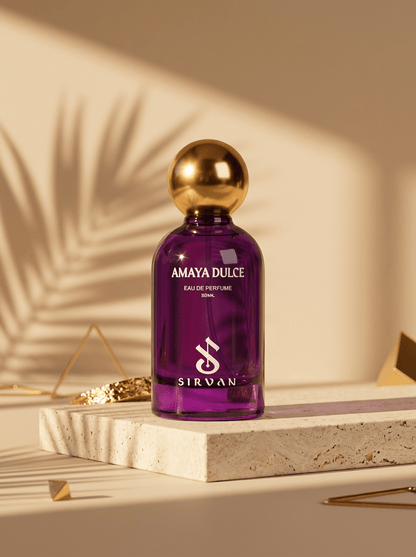 A purple, cruelty-free SIRVAN Amaya Dulce Eau de Parfum with gold cap rests on a stone slab with palm leaf shadows.